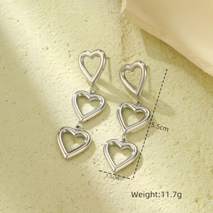Detail view of silver heart earrings with dimensions 5.5cm length and weight 11.7g