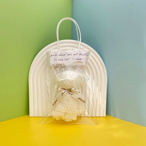 White coral fleece towel folded into bear shape in transparent PVC gift bag with pearl detail