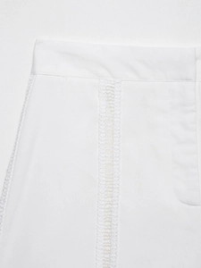 Gros plan sur le short en lin blanc avec des détails de broderie au crochet ajourée