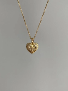 Detailed view of a gold heart pendant necklace with shimmering micro-paved crystal stones