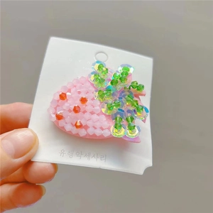 Handmade strawberry hair clip with pink crystal beads and sequins on a white card