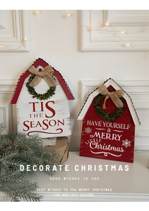Detail of wooden Christmas door sign with burlap bow and wreath on white wall background