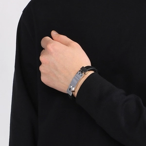 Close-up of men's black braided leather bracelet with a polished silver stainless steel clasp