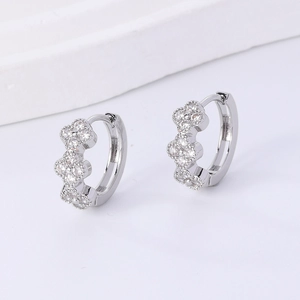 Detailed close-up of silver clover hoop earrings with sparkling round cubic zirconia