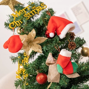 Close-up of festive Christmas tree decorations with red plush hats and gold Merry Christmas sign