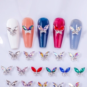 Macro detail of multi-colored aurora butterfly nail charms with metallic base on manicure