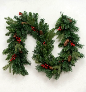Detailed view of green PE mixed Christmas garland with red berries and brown pine cones