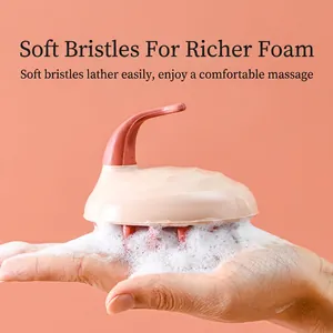 Pink handheld silicone scalp massager brush creating rich foam for hair washing