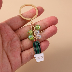 Close-up of beaded cactus keychain with golden ring and white wave pattern pot