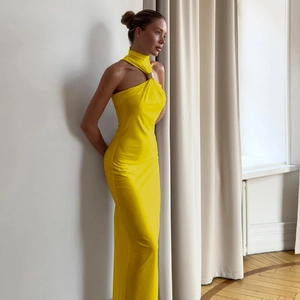Dettaglio dell'abito giallo con scollo all'americana, anello metallico e vestibilità slim