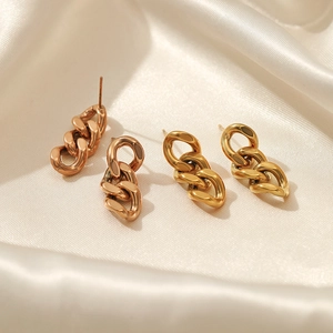 Minimalistische Panzerketten-Ohrringe in Gold und Roségold auf weißem Seidenstoff