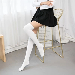 Detailed texture of white over-the-knee cotton socks on a model in a cozy setting
