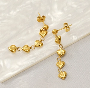 Détail macro de boucles d'oreilles cœur en plaqué or 18 carats avec texture fine