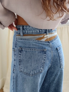 Ausgestellte Jeans mit hoher Taille in Hellblau und farbigem Detail am hinteren Bund