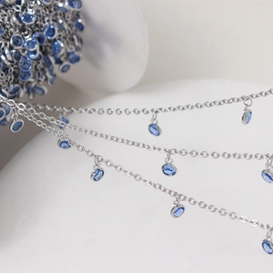 Macro shot of silver metal chain with blue circular gemstones for DIY jewelry making