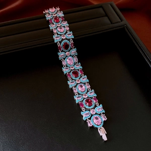 Dettaglio del bracciale vintage in argento con zirconi rosa e blu su seta rossa