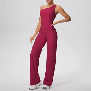 Détail du débardeur de yoga bordeaux à une épaule et du pantalon large à taille haute