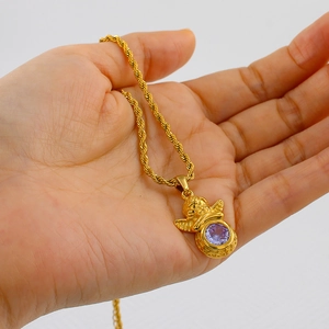 Detailed view of a gold angel pendant necklace featuring a purple zircon on a rope chain