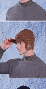 Detail view of winter knitted cap with warm earflaps and white snowflake embroidery