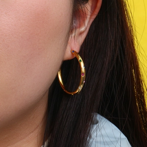 Detailed close-up of a 316L gold stainless steel hoop earring with multi-color zircon stones