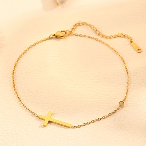 Polished gold stainless steel cross bracelet with sparkling cubic zirconia on cream leather