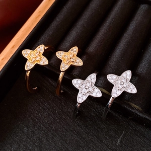 Macro view of C-shape flower earrings with zirconia stones in gold and silver plating