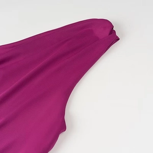 Gros plan détaillé du tissu de robe fuchsia avec texture lisse et drapé élégant