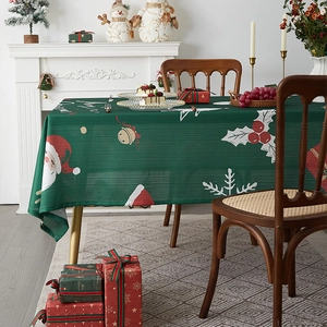 Detail of green Christmas tablecloth with Santa Claus and holly festive patterns