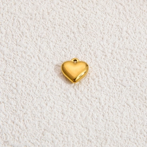 Close-up of polished 18k gold-plated heart pendant with minimalist sunburst engraved detail