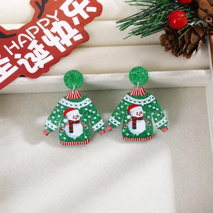 Close-up of green glitter snowman earrings displayed in a festive gift box with pine cones