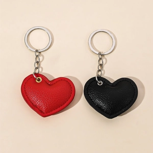 Leather heart-shaped keychain set in red and black with textured finish and silver rings