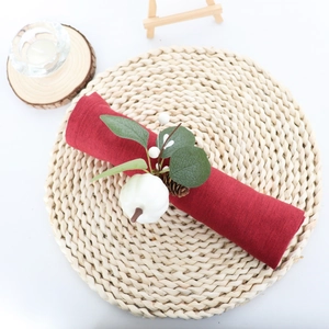 White pumpkin and eucalyptus leaf napkin ring on dark red linen for table decor