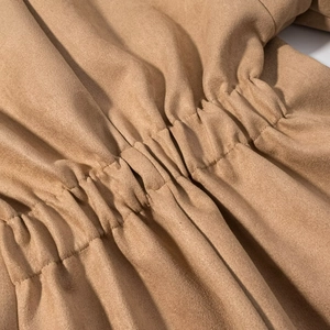 Detailed macro view of khaki faux suede fabric texture and elastic ruched waist stitching