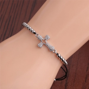 Detail of adjustable black woven bracelet with silver beads and zircon cross pendant