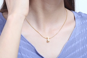 Close-up of minimalist gold cat pendant necklace worn by a model for a lifestyle view