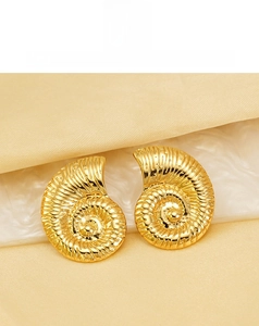 Macro di orecchini a spirale a conchiglia placcati in oro 18K con texture metallica