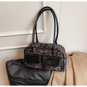 Detail of leopard print suede shoulder bag featuring black leather pockets and gold hardware