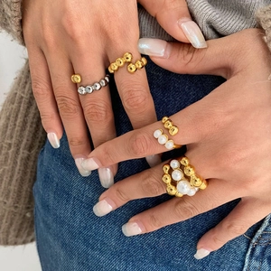 Bagues perlées dorées et argentées avec perles portées par un mannequin sur denim