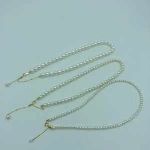 Detailed view of three sizes of round pearl necklaces with 14k gold-filled clasps