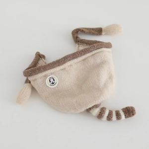 Detail of knit baby winter hat with animal ears and circular fashion logo patch