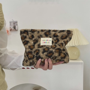 Detailed close-up of leopard print plush cosmetic bag with soft faux fur texture