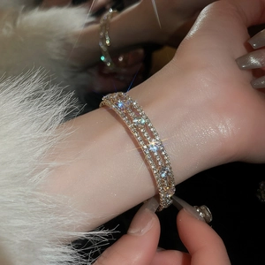 Close-up of triple-row gold bracelet with sparkling cubic zirconia on a wrist