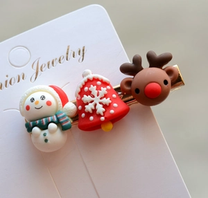 Detailed close-up of festive Christmas hair clips featuring reindeer and snowman motifs