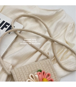Detail of hand-woven straw bag with pink flower pattern and adjustable cord strap