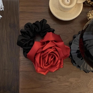 Gros plan d'un grand chouchou rose rouge en satin avec une texture vintage française élégante
