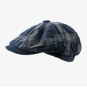 Détail d'une casquette gavroche en velours côtelé à carreaux bleus et gris avec bouton