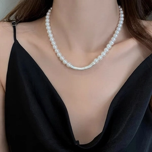 Collier de perles élégant avec tube en métal argenté porté par un mannequin
