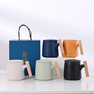 Minimalist ceramic mug set with wooden handles and lids in an elegant blue gift box