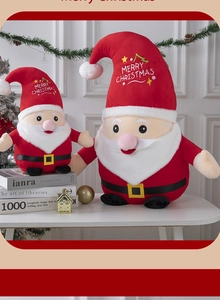 Detail of plush Santa Claus dolls in two sizes with Merry Christmas hat on a white table