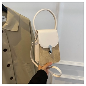Detail of two-tone PU leather crossbody bag with silver metal ring handle and flap closure